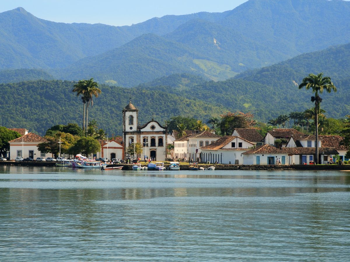 Colonial waterfront town of Paraty with palm trees and mountains in the background, Rio de Janeiro coast